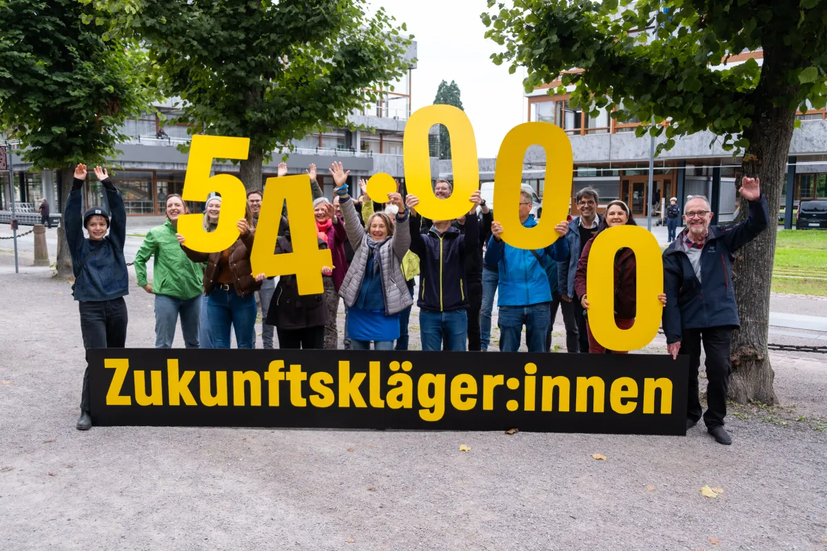 Eine Gruppe von Menschen steht vor dem Bundesverfassungsgericht, vor ihnen ein Banner mit der Aufschrift Zukunftsklägerinnen